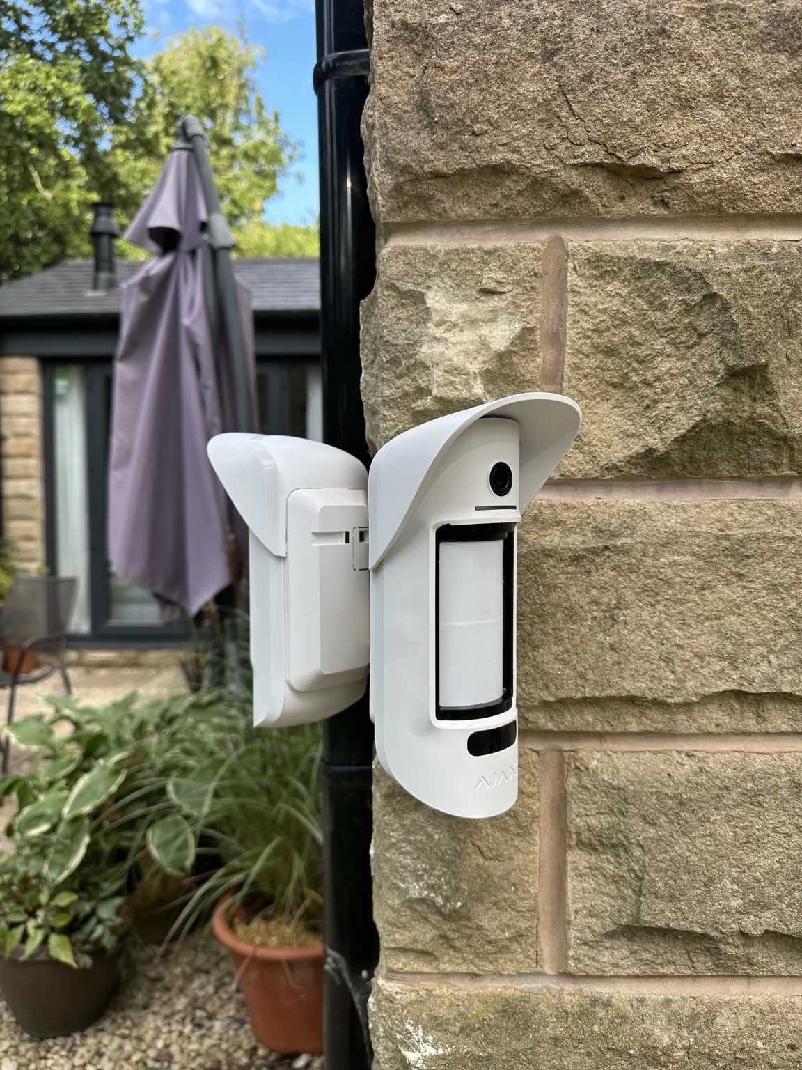Side angle showing the Ajax outdoor detector and mounting bracket
