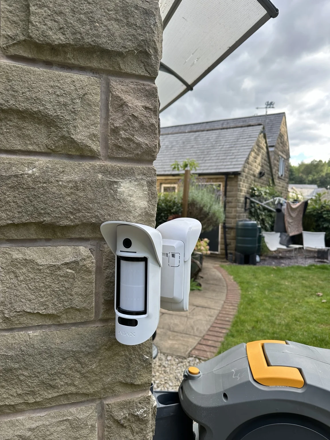 Ajax outdoor motion detector on a natural stone corner