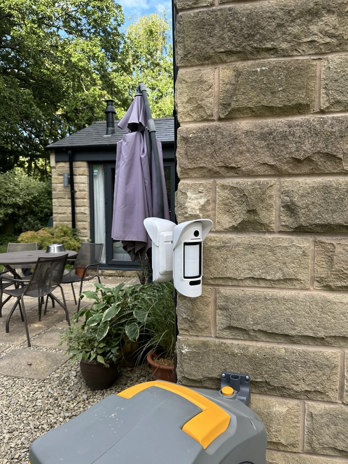 White Ajax MotionCam Outdoor detector overlooking the patio