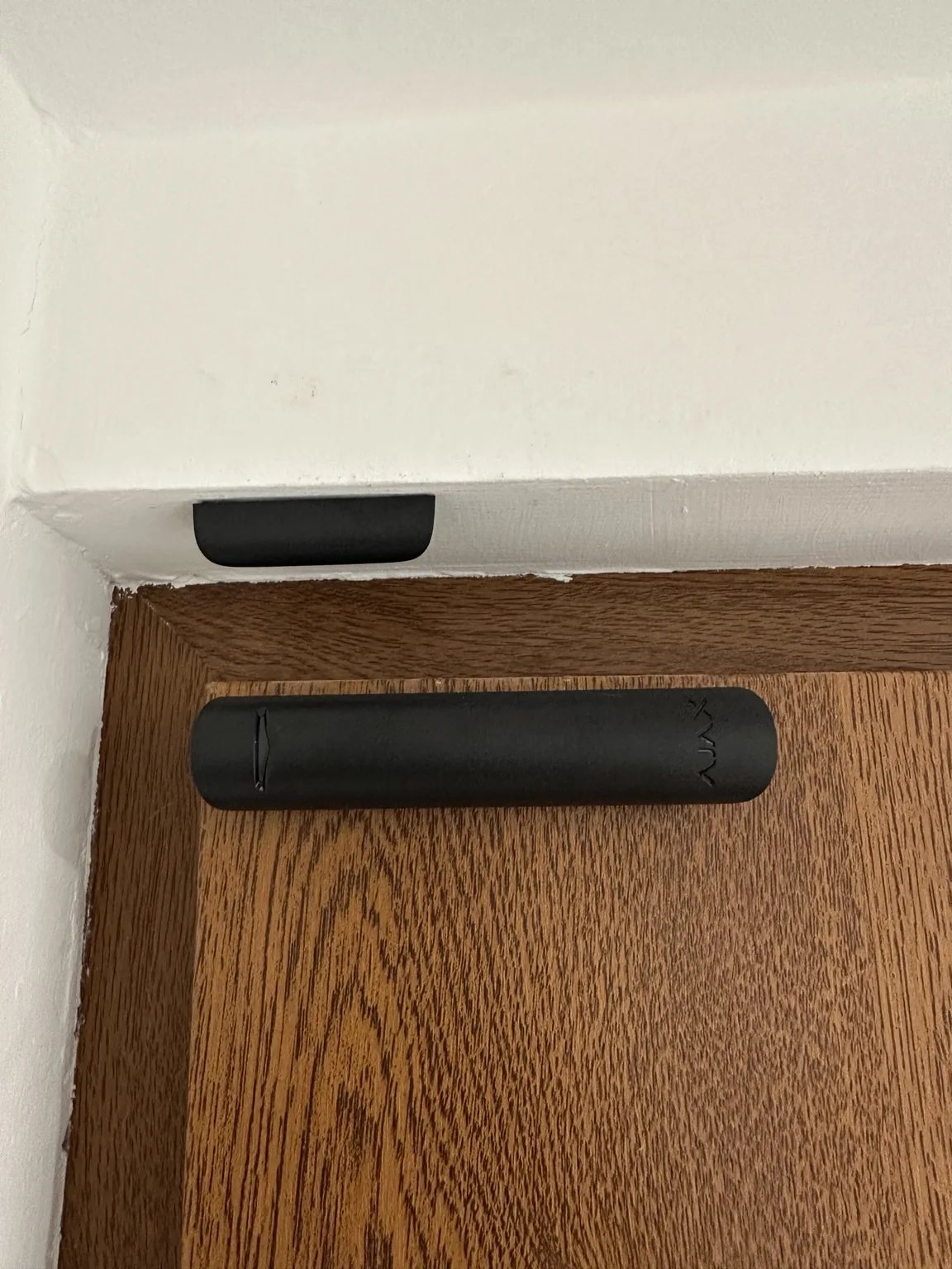 Black Ajax door contact fitted to a timber door
