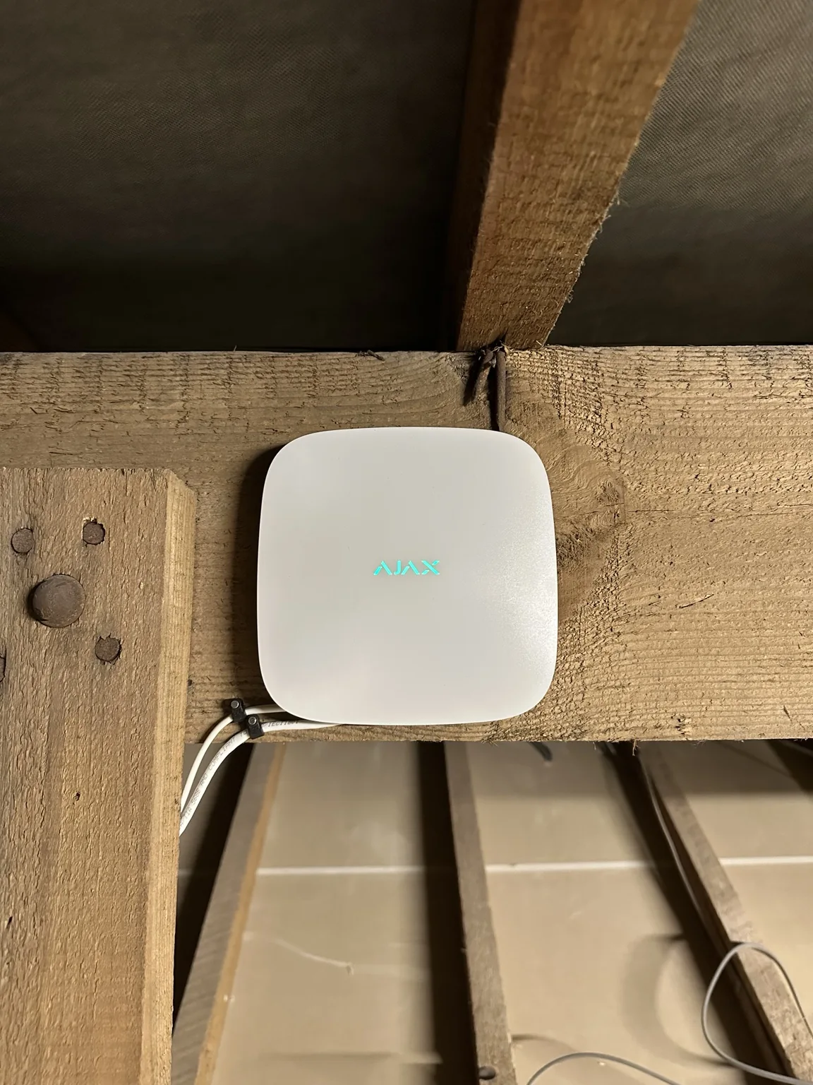 White Ajax security hub mounted in the bungalow loft