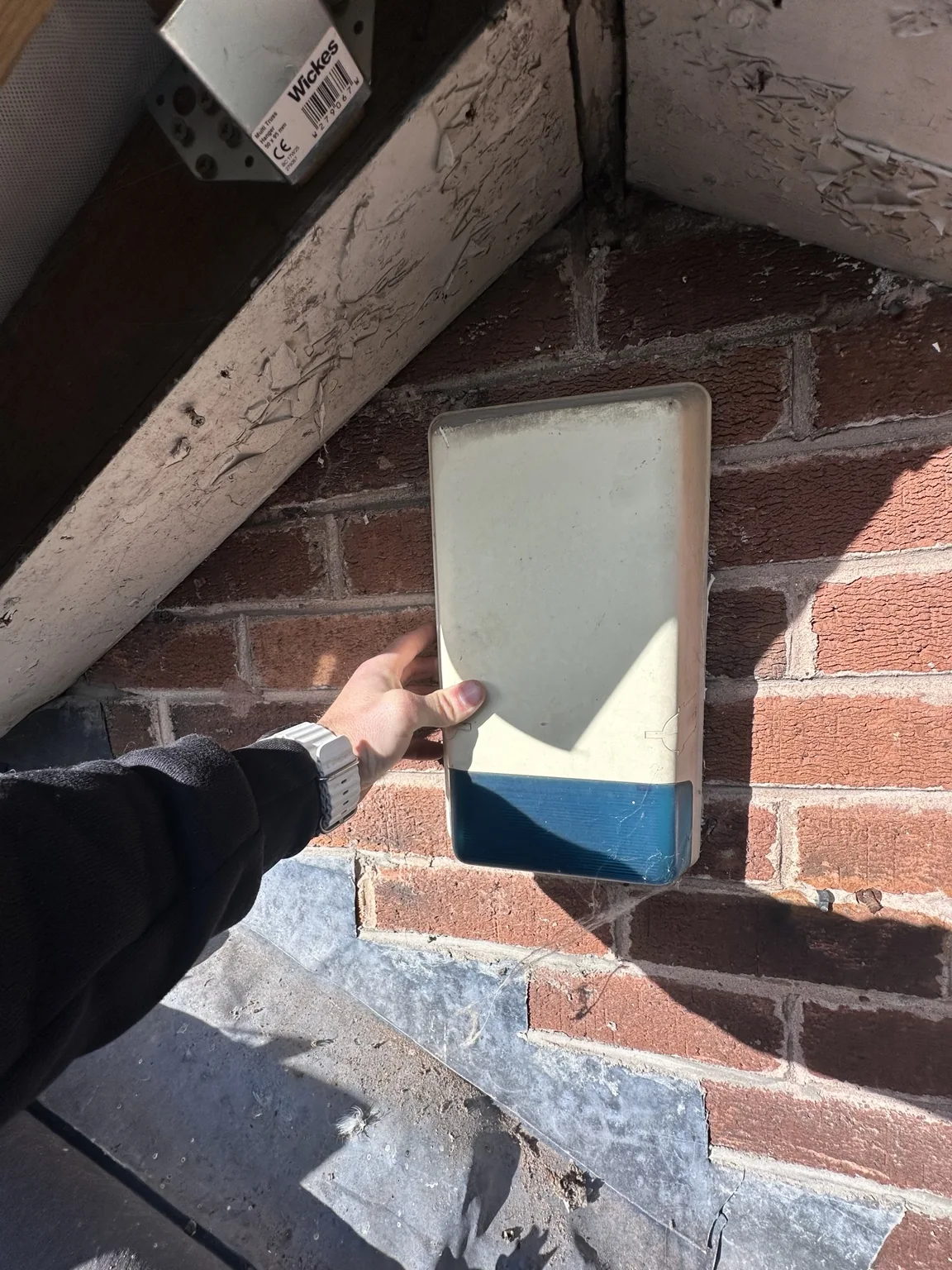 Older exterior alarm siren on the brick bungalow wall